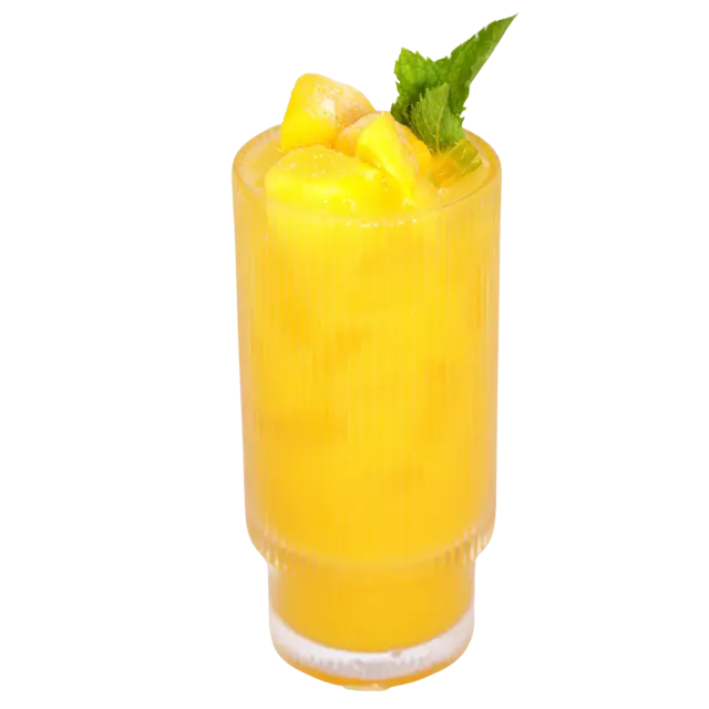 Fresh mango juice over ice, topped with mango chunks and a sprig of mint