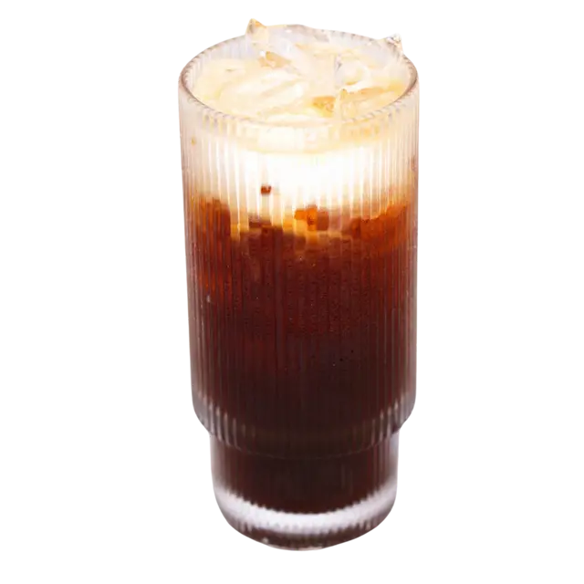 Thai iced coffee layered with cream over ice in a fluted glass